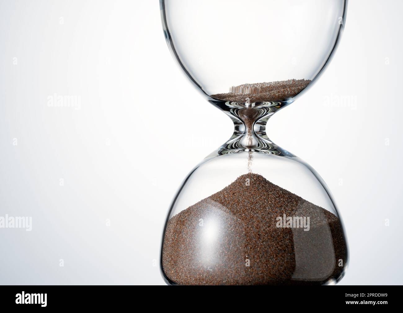 An hourglass placed on a white background. Stock Photo