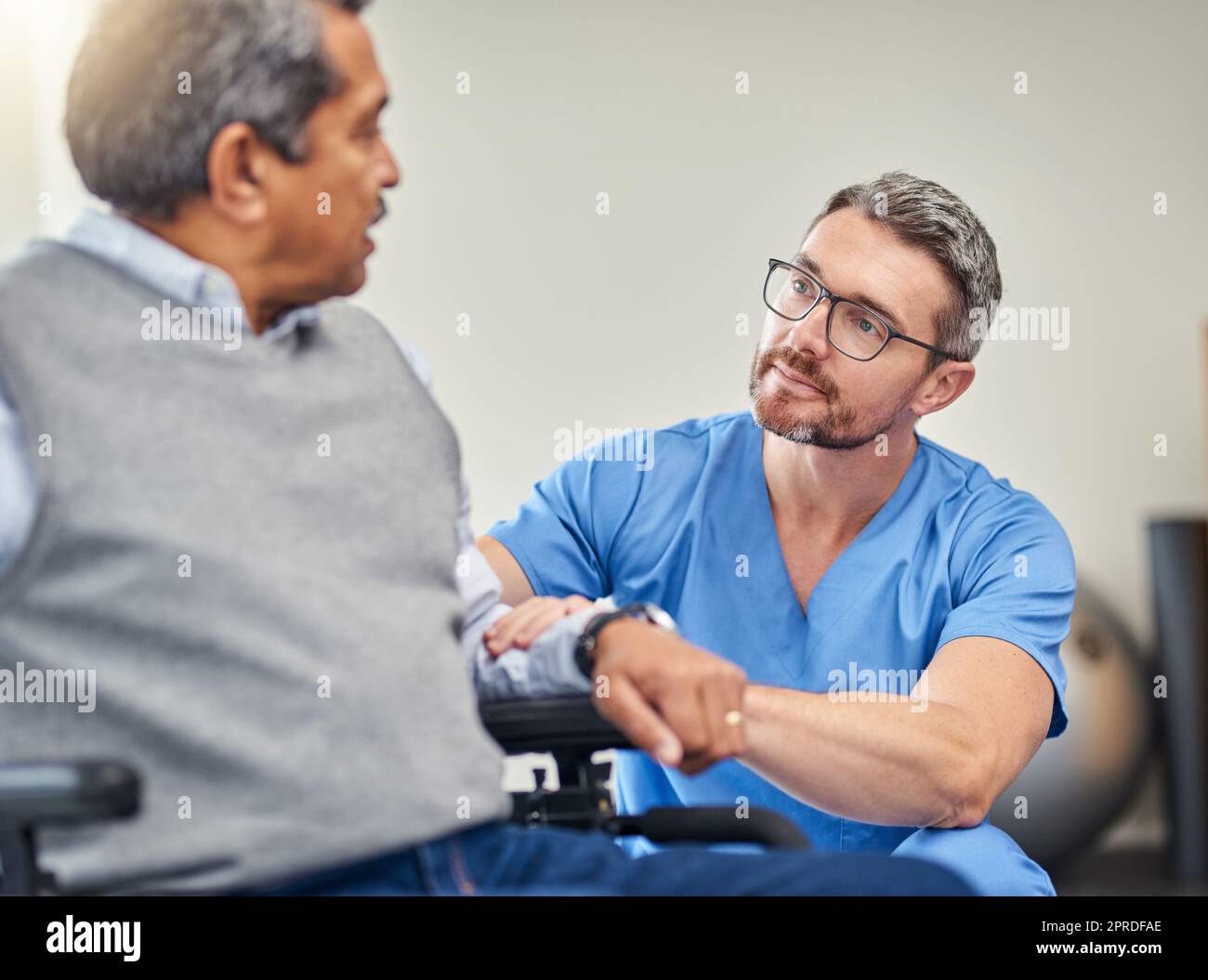 Making mobility a bit more easier. a nurse helping a senior man in a wheelchair Stock Photo Alamy