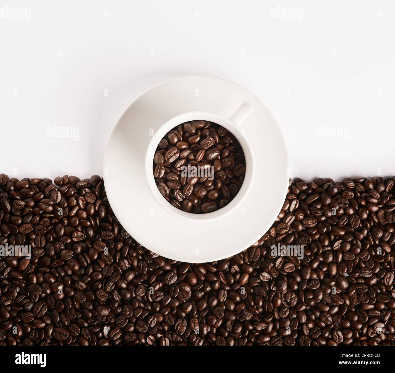 Life would be boring without coffee. Closeup shot of a cup filled with coffee beans against a half-and-half background. Stock Photo