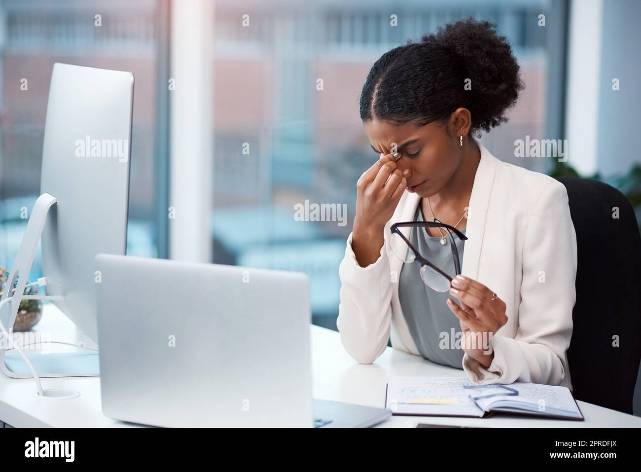 Stressed, tired and frustrated businesswoman with headache, eye strain and burnout making mistake on office laptop. Overworked creative entrepreneur failing to meet deadline or plan startup strategy Stock Photo