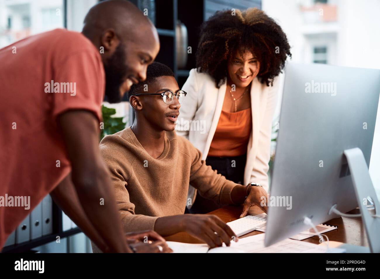 Were using the right platform to get our work out there. a group of businesspeople looking at something on a computer screen in an office. Stock Photo