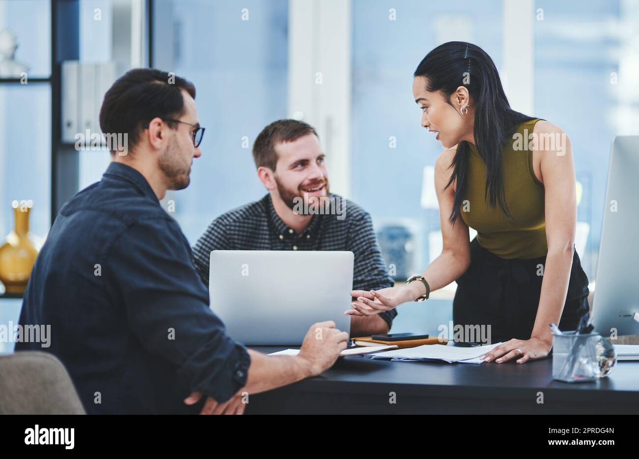 Moving their agency forward together. a group of young designers having a discussion in an office. Stock Photo