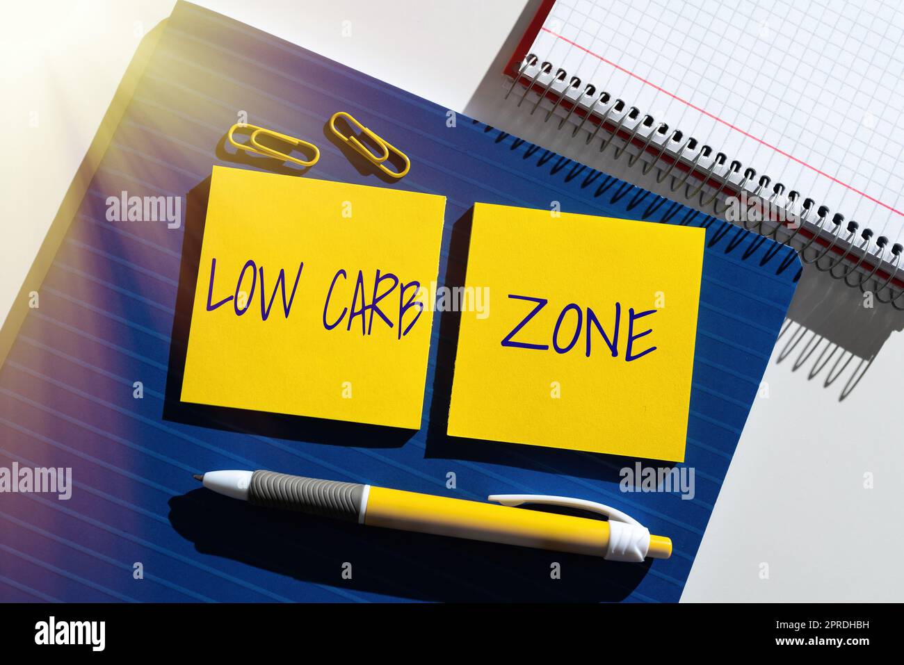 Handwriting text Low Carb Zone. Concept meaning Healthy diet for losing weight eating more proteins sugar free Important News Presented On Two Sticky Notes On Desk With Notebook And Pen. Stock Photo