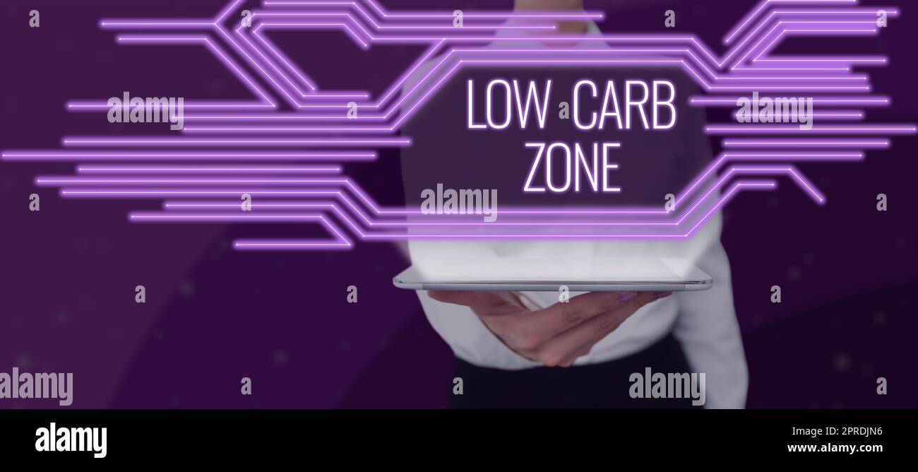 Hand writing sign Low Carb Zone. Word Written on Healthy diet for losing weight eating more proteins sugar free Woman With A Tablet Displaying Glowing Lines In Futuristic Frame. Stock Photo