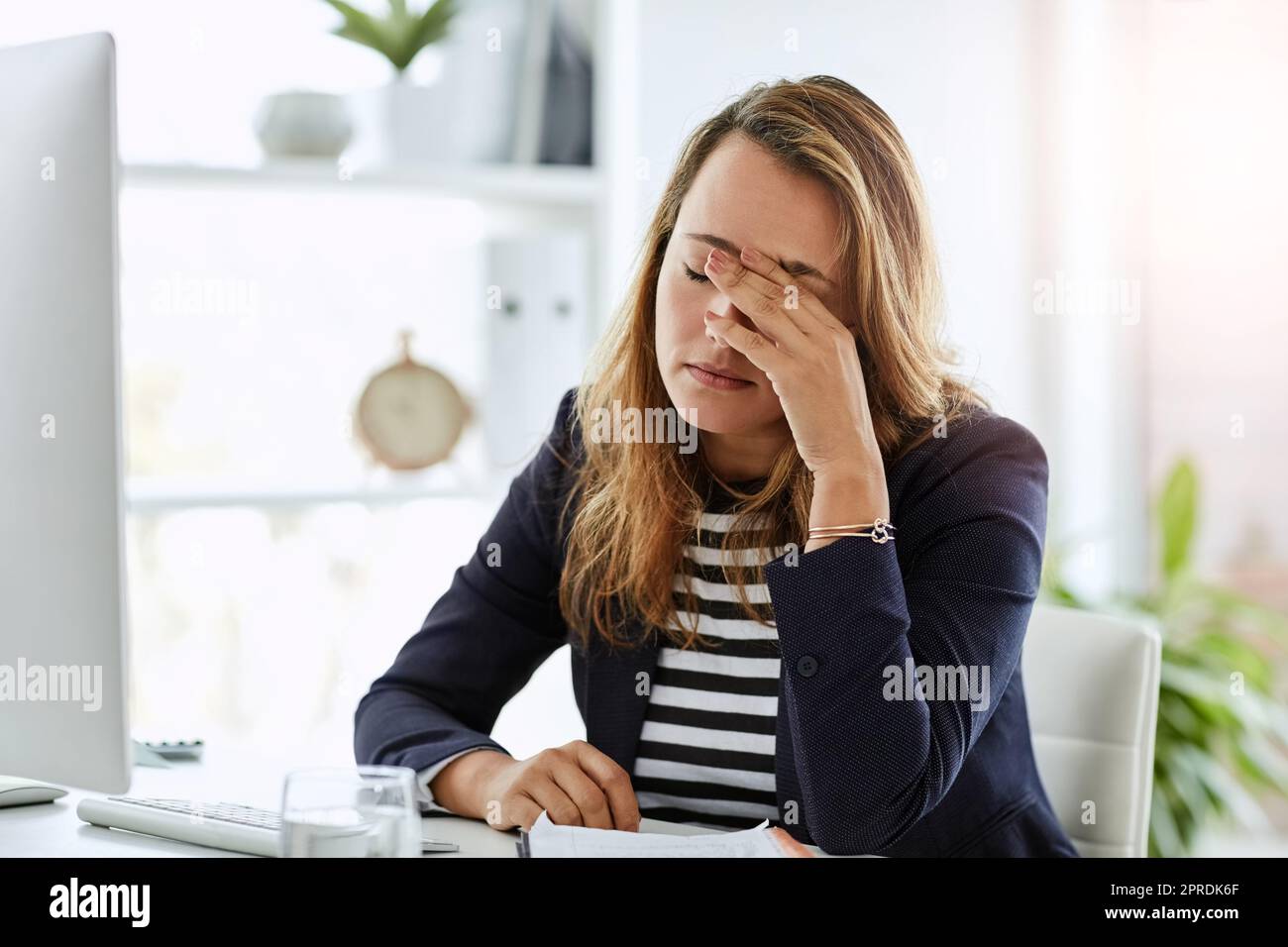 Everything is just starting to go haywire. an attractive businesswoman looking overly stressed out in her office at work. Stock Photo