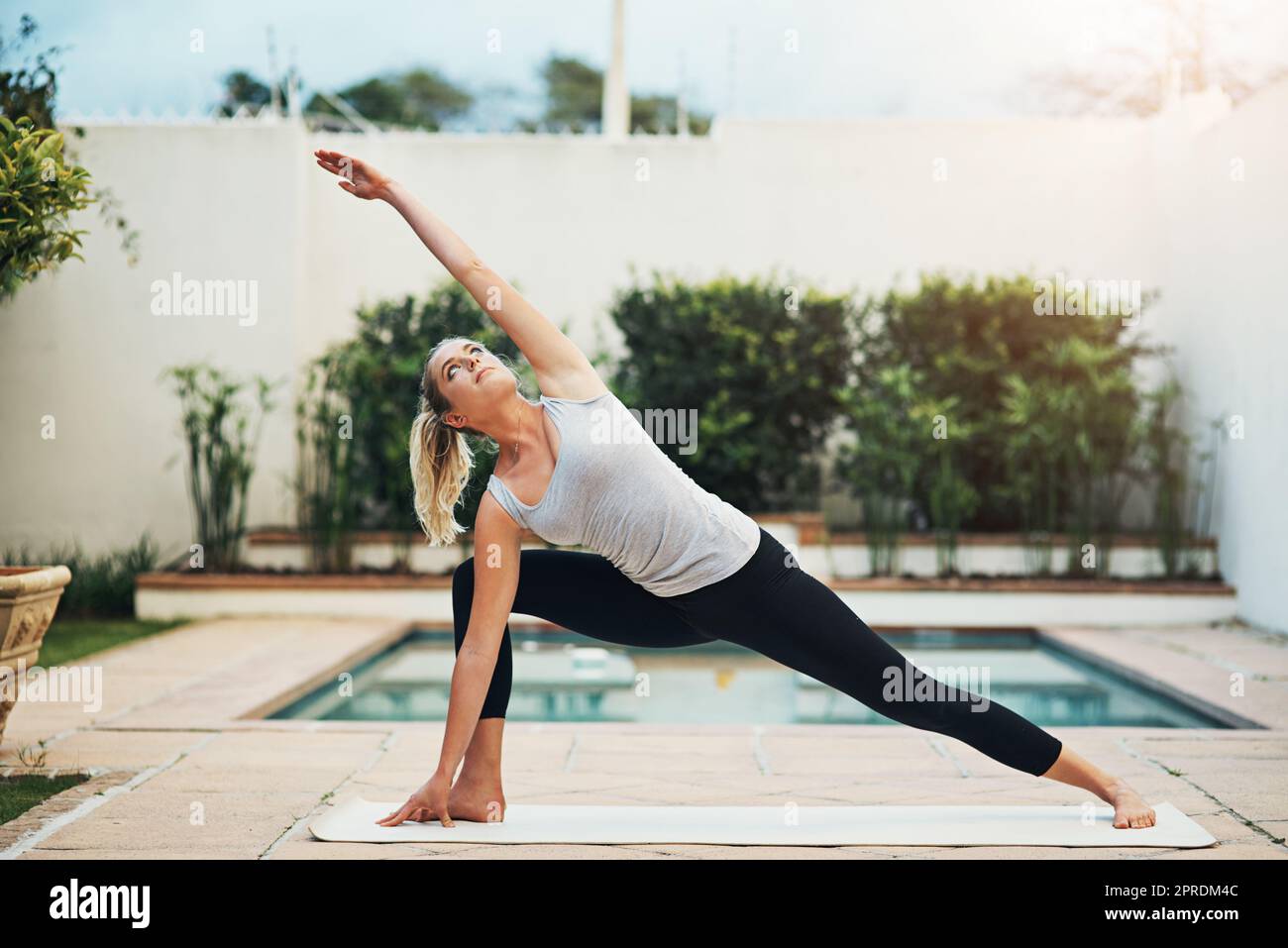 Keep calm and do yoga. a young woman doing yoga poolside. Stock Photo