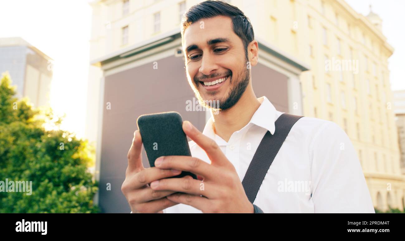 Today seems pretty exciting from the get go. a handsome young businessman using his cellphone while walking through the city. Stock Photo