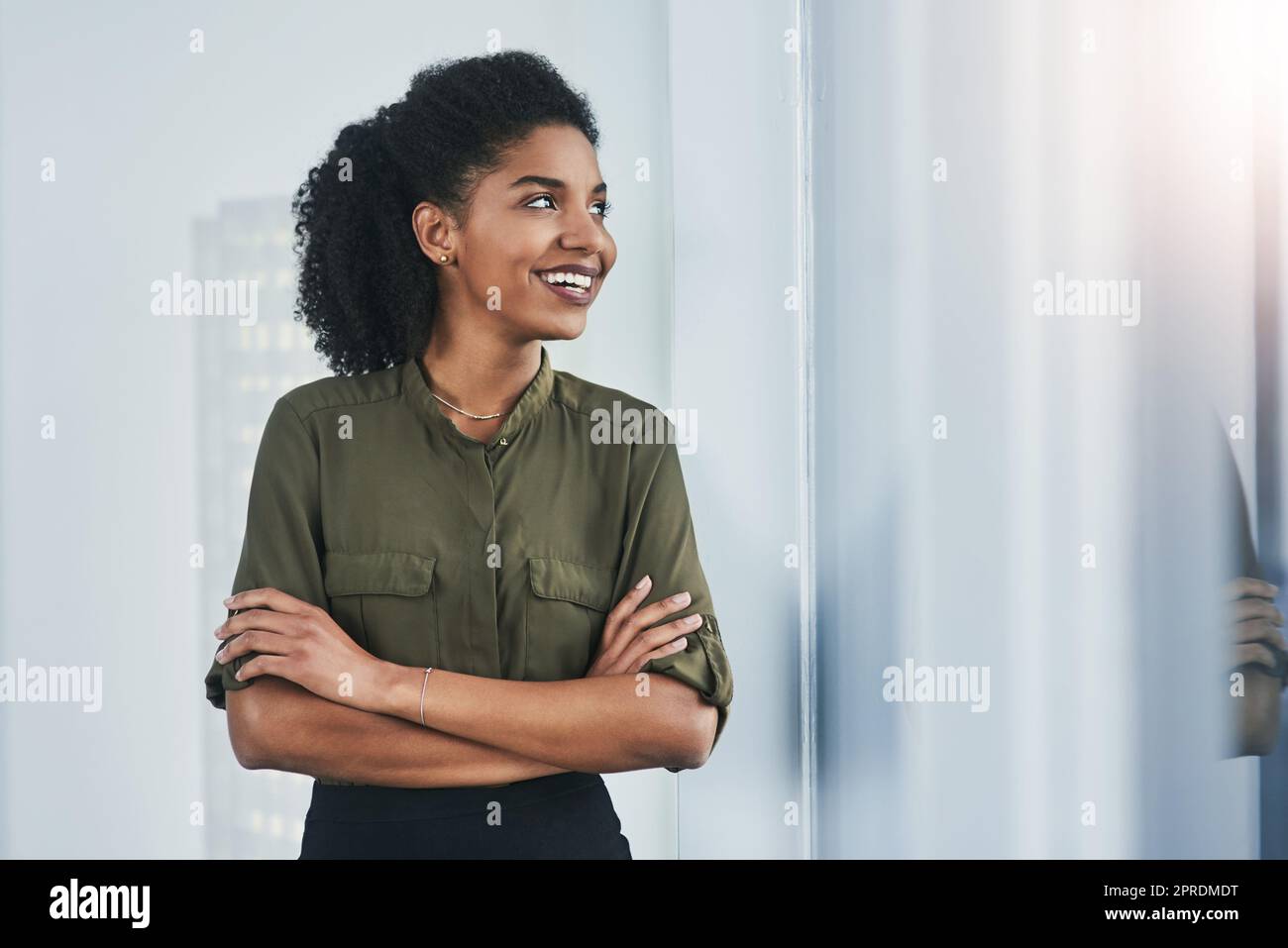 Your thoughts always govern your actions, think positive. a confident young businesswoman looking out of a window in her office. Stock Photo