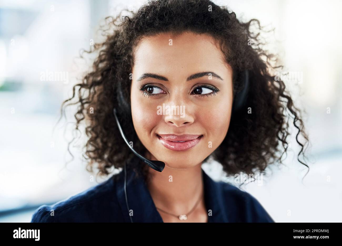 She has an idea that might help. an attractive young female call center agent looking thoughtful while working in her office. Stock Photo