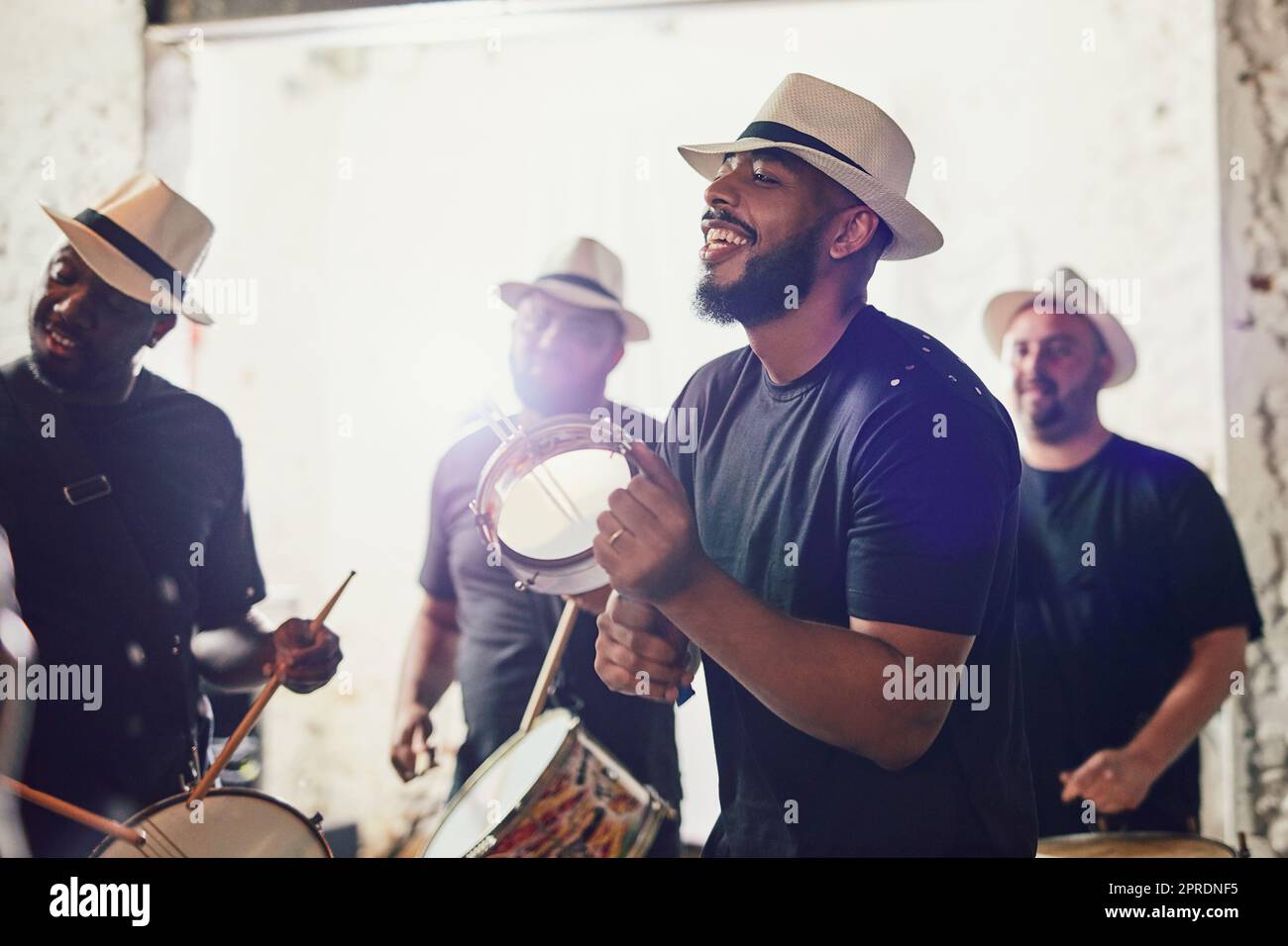 Their music makes you want to get up and dance. a group of musical performers playing drums together. Stock Photo