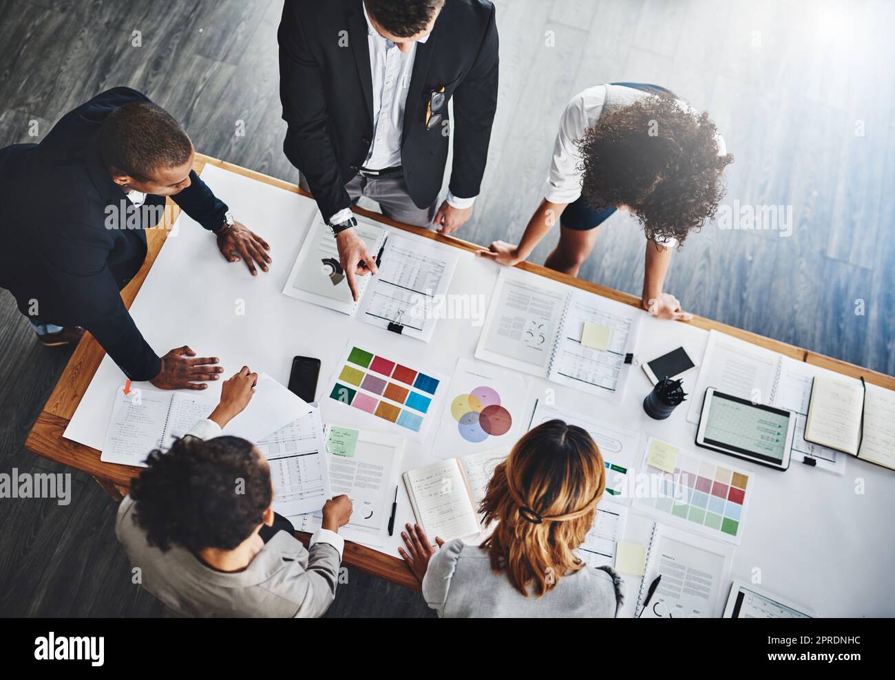 Diving straight into their business stats. High angle shot of a group of businesspeople having a meeting in an office. Stock Photo
