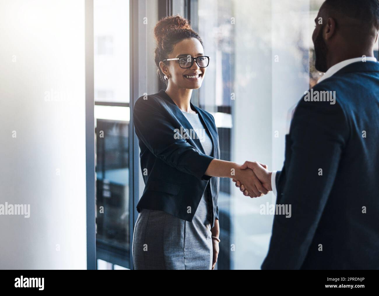 Im happy we could finally meet face to face. two businesspeople shaking hands in an office. Stock Photo