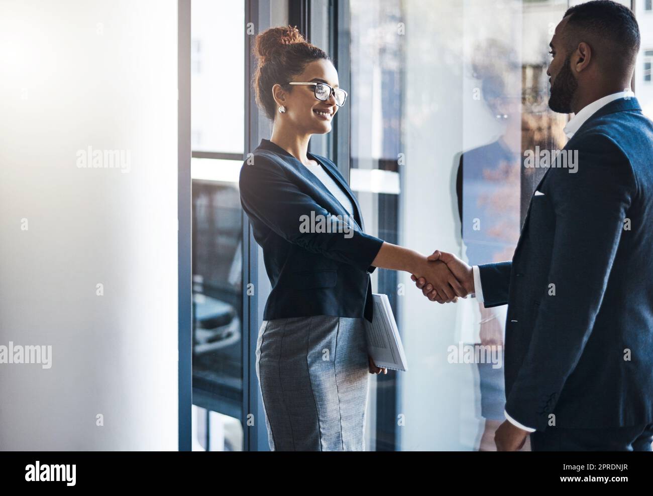 Collaborate with those who inspire you. two businesspeople shaking hands in an office. Stock Photo