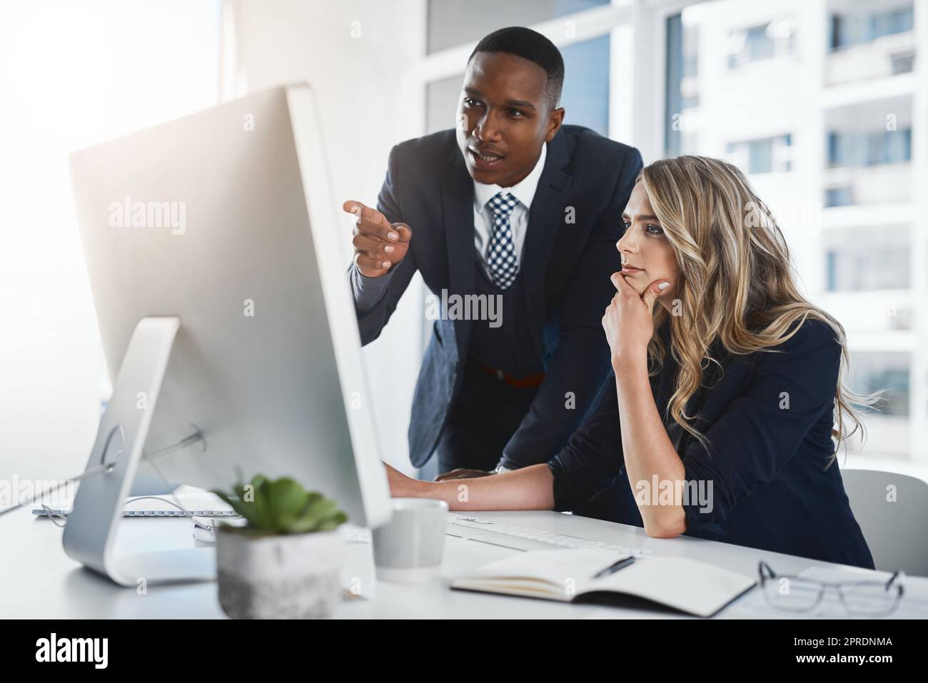 This might be a way of rapidly boosting our profits. two businesspeople working together in an office. Stock Photo