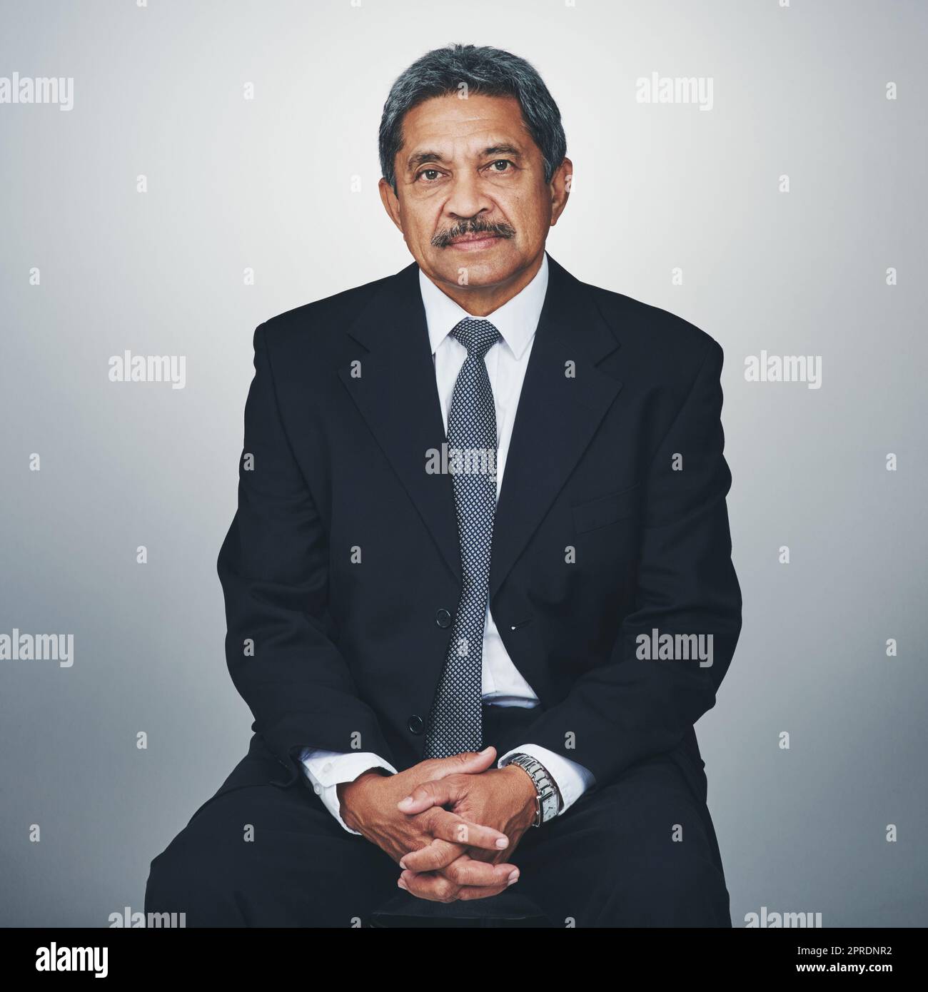 Hes experienced in his field. Studio portrait of a mature businessman posing against a grey background. Stock Photo