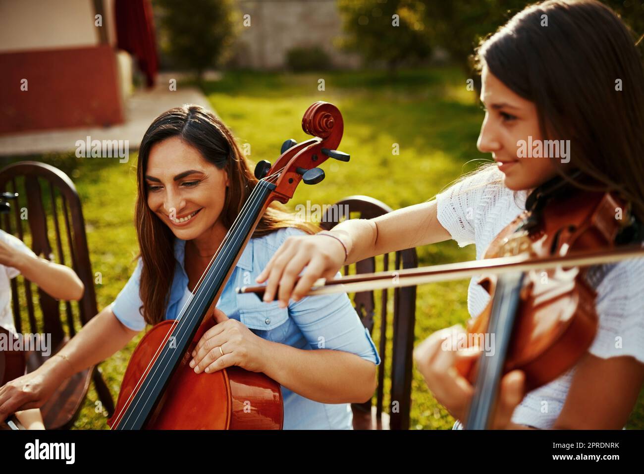Playing music with her daughter brings her joy. a beautiful mother playing instruments with her adorable daughter outdoors. Stock Photo