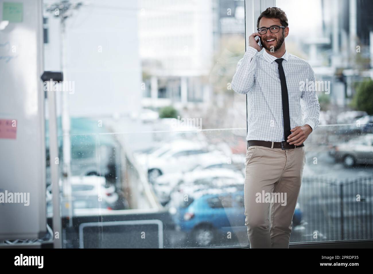 Success lies in your confidence to chase after it. a young businessman talking on a cellphone in an office. Stock Photo