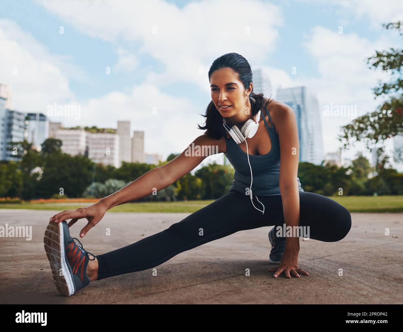 You gotta stretch to get the blood flowing. Full length shot of an attractive young sportswoman doing stretch exercises outdoors in the city. Stock Photo