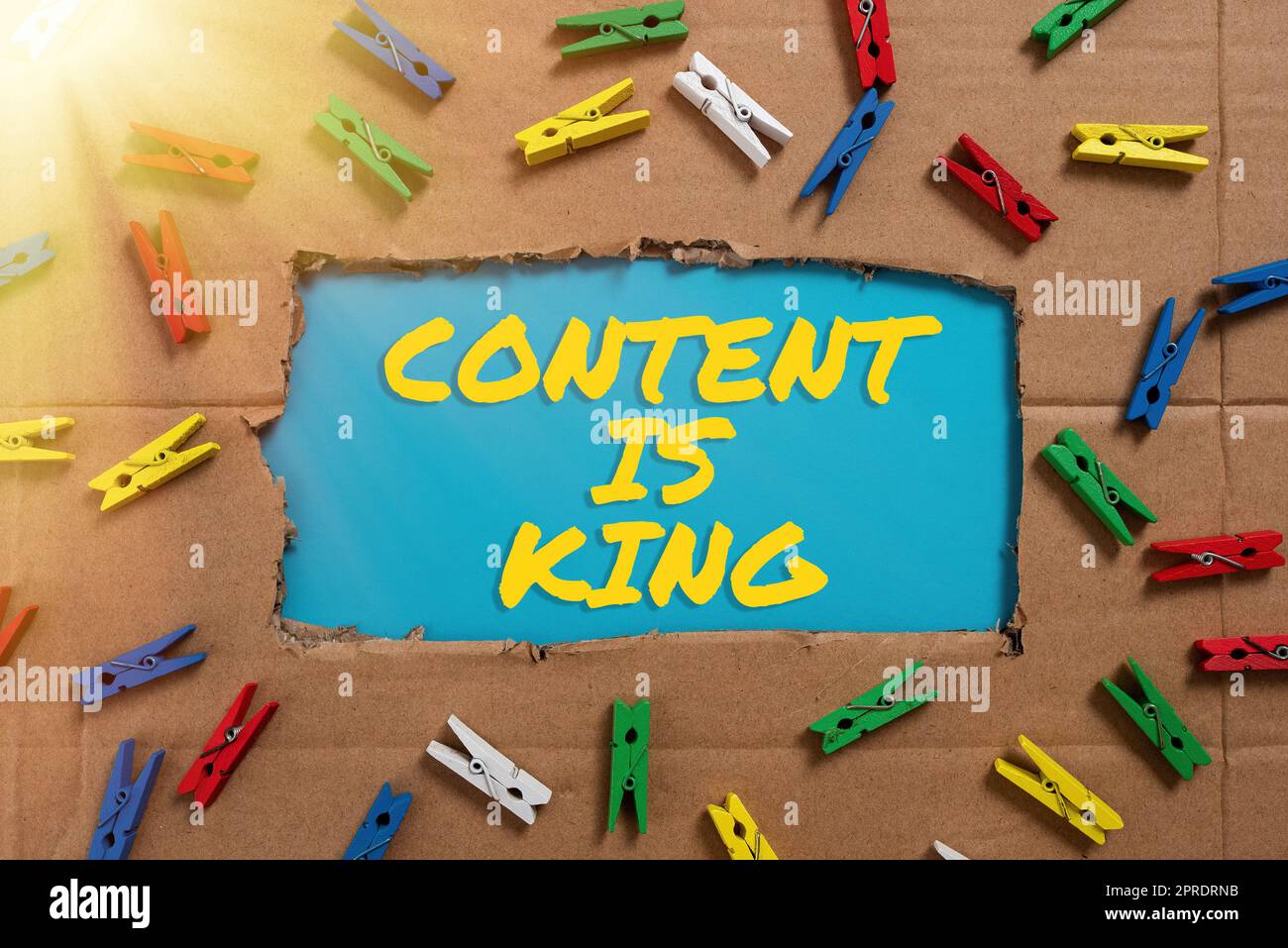 Hand writing sign Content Is King. Business approach Content is the heart of todays marketing strategies Important Ideas Written Under Ripped Cardboard With Colored Pegs Around. Stock Photo