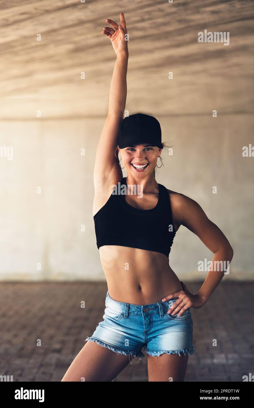 Raise a hand if youre hip and happening. an attractive young female street dancer posing with her arm raised while practising out in the city. Stock Photo