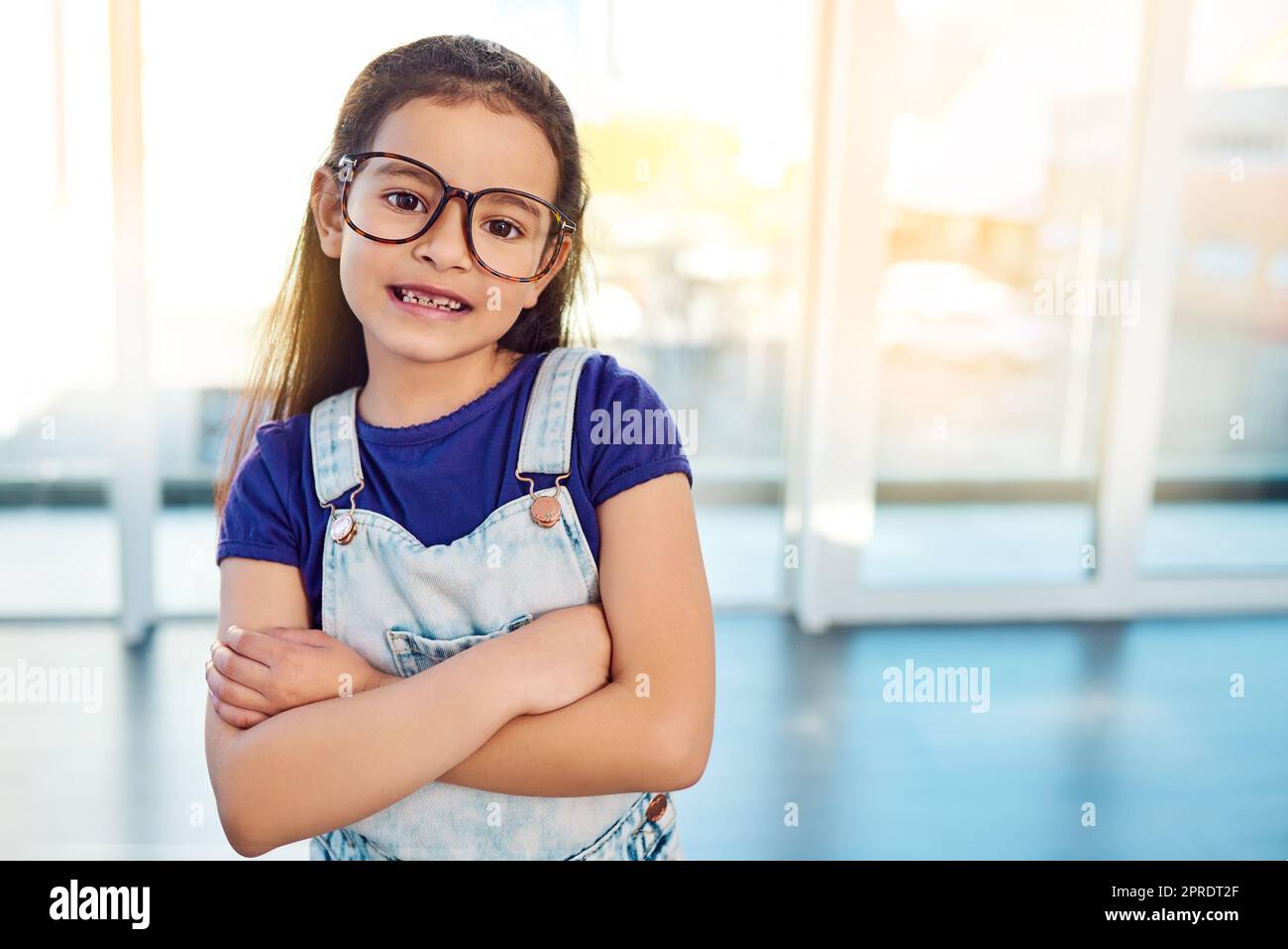 Smart girls run the world. Portrait of an adorable little girl with glasses on posing with her arms folded at home. Stock Photo