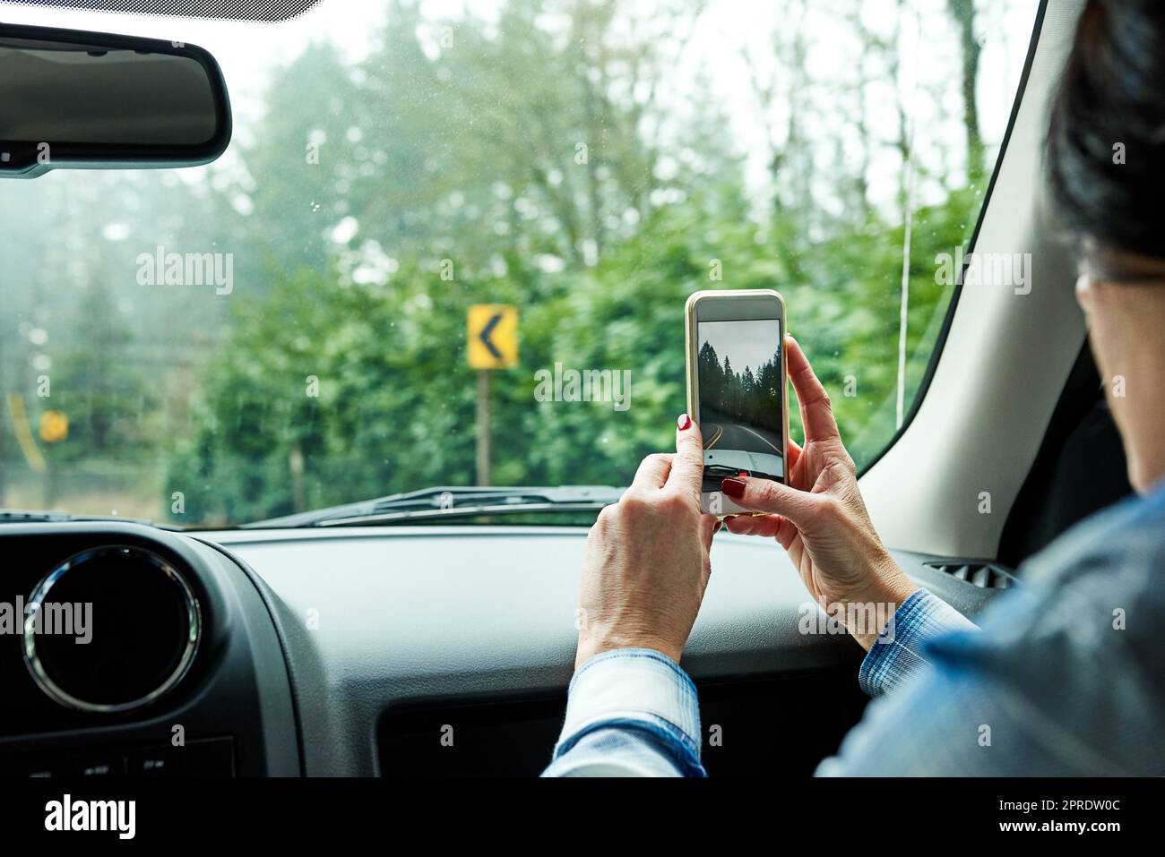 Taking pictures along the way. a passenger taking pictures while out on a road trip. Stock Photo