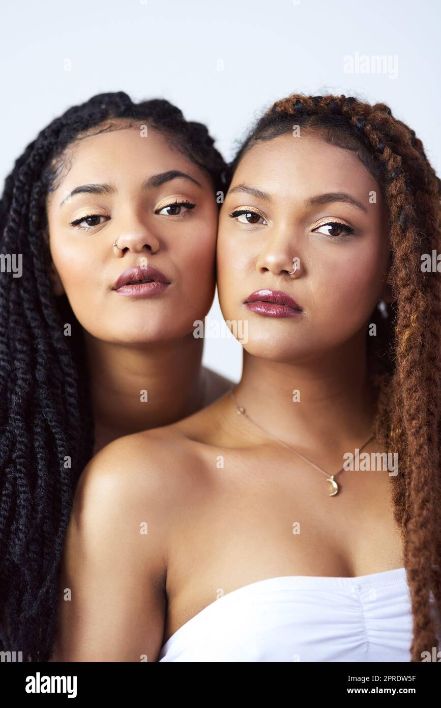 Naturally beautiful. Studio shot of two beautiful young women posing against a grey background. Stock Photo