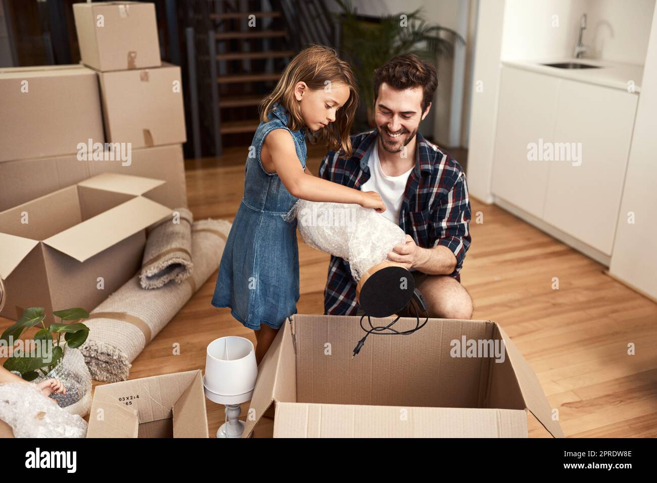 Packing boxes together. a young father and his adorable little daughter