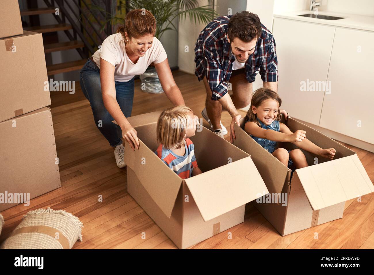 Having fun with the boxes. a young family on their moving day. Stock Photo