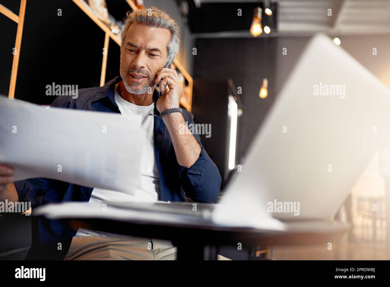 I just wanted to run some things by you... a handsome mature businessman working in his local internet cafe. Stock Photo