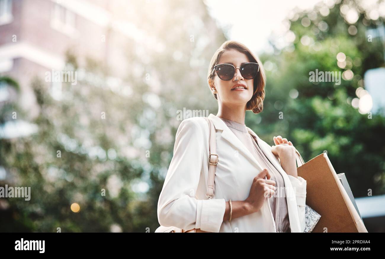 Elegant woman holding shopping bags after a spending spree, retail therapy and buying clothes in a city. Trendy, stylish and fashionable lady purchasing gifts, presents and classy clothing downtown Stock Photo