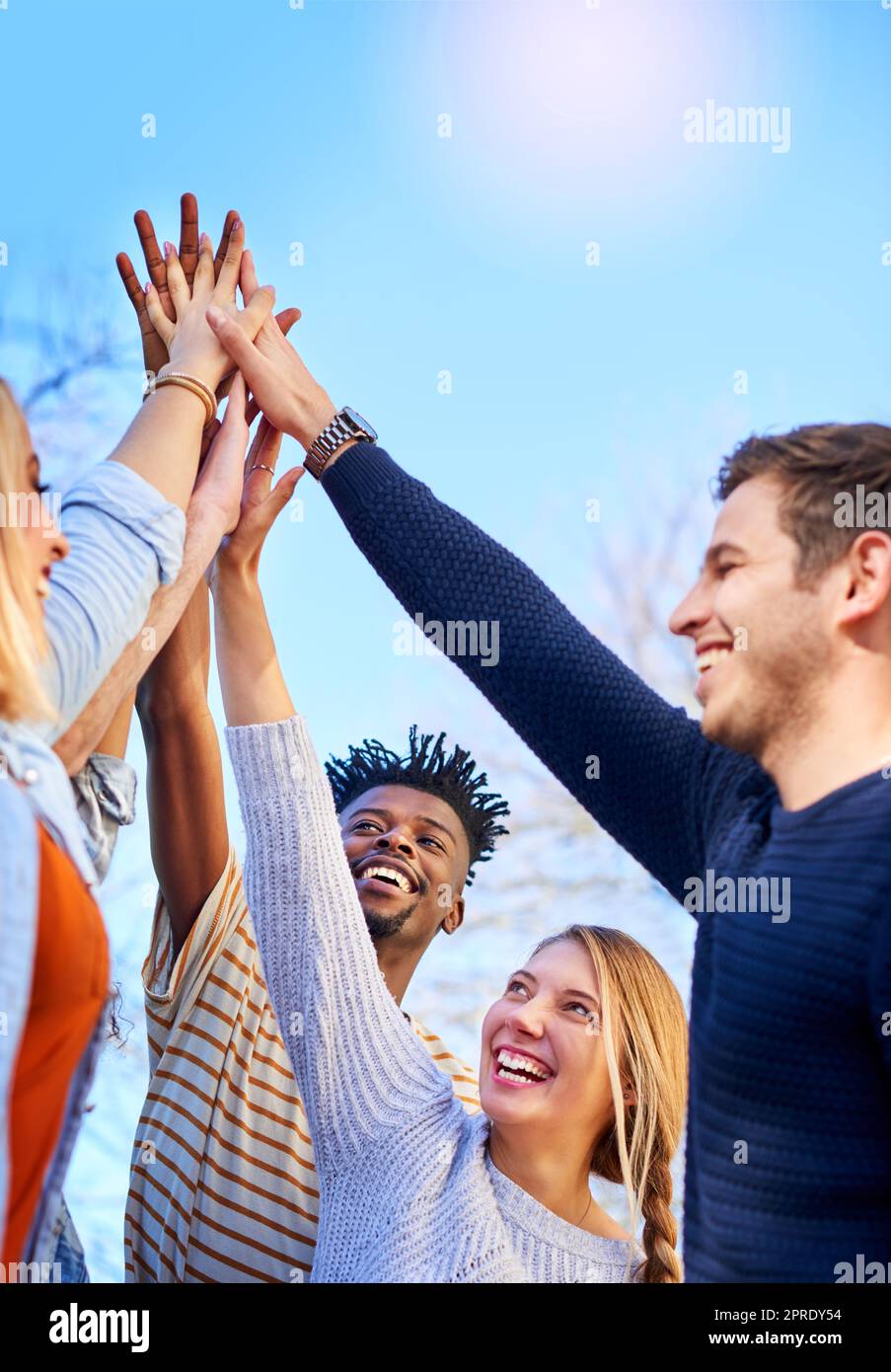 Time to celebrate passing the year. university students standing outside with their hands together. Stock Photo