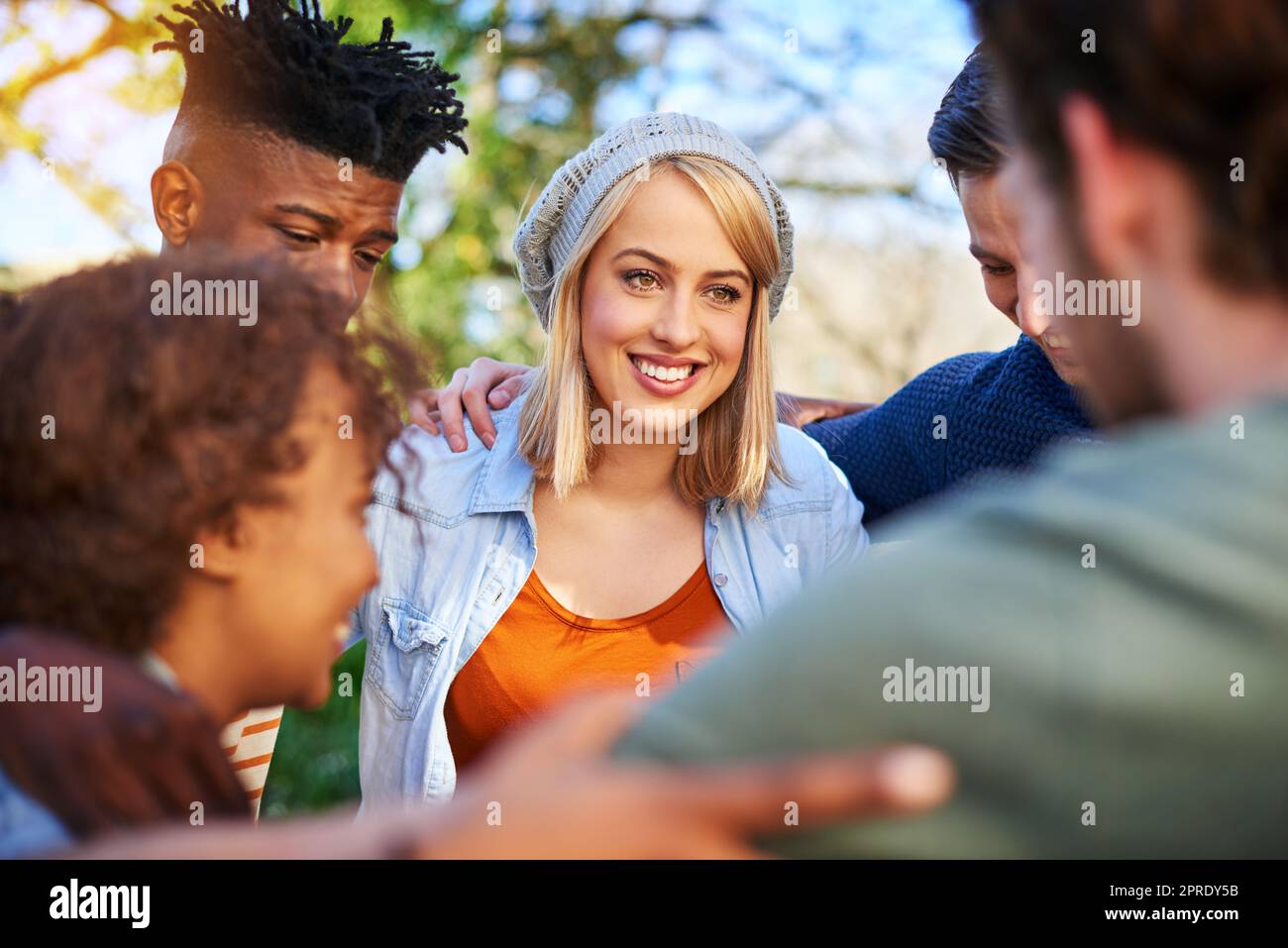Our teamwork could make anything work. a group of students hanging out together outside on campus. Stock Photo
