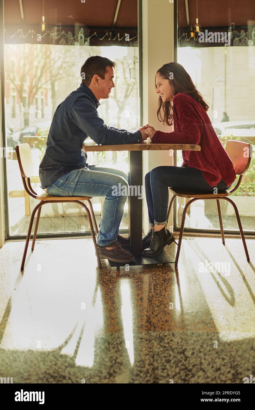 Their favourite spot for a bit of romance. a young man and woman on a romantic date at a coffee shop. Stock Photo