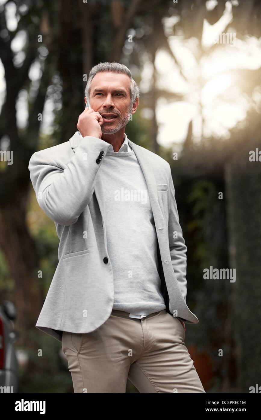 Calling the office from anywhere. a smartly dressed mature businessman on a call outside. Stock Photo