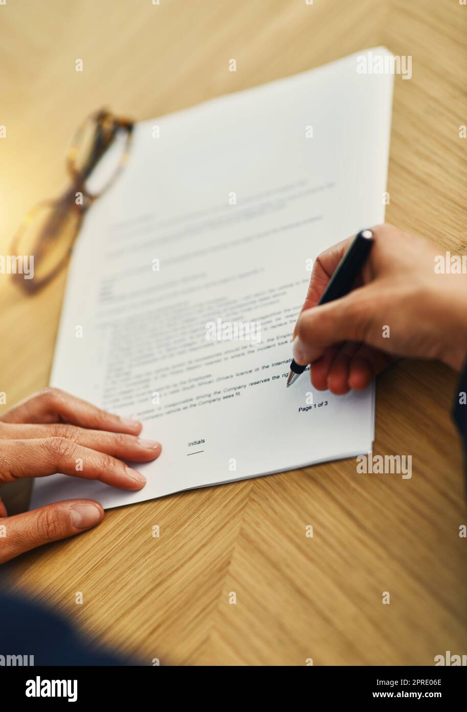 Signing a new deal. Closeup shot of an unrecognizable businesswoman completing paperwork at a desk. Stock Photo