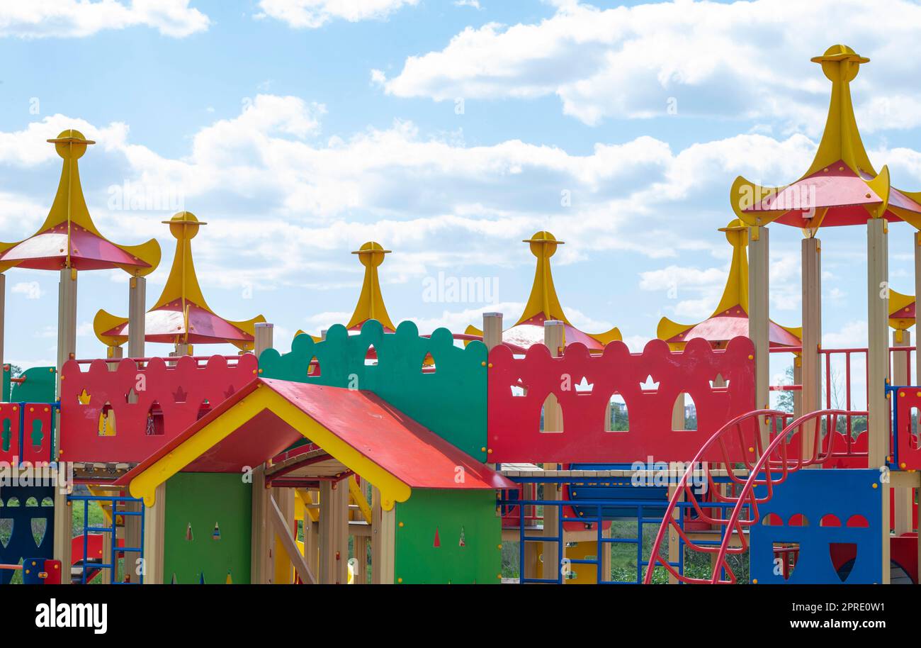 Modern public playground against the blue sky. A colorful play and sports complex for children without people. Equipment for rock climbing and assault on the playground. Stock Photo