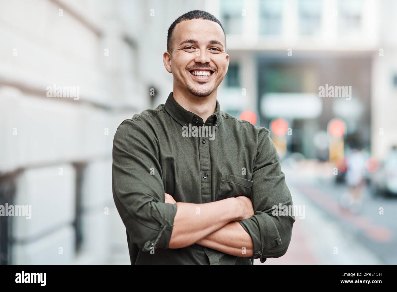 Business man standing with arms crossed, looking confident and proud in the city alone. Portrait of a black male entrepreneur or worker showing vision, ambition and success with arms folded downtown Stock Photo