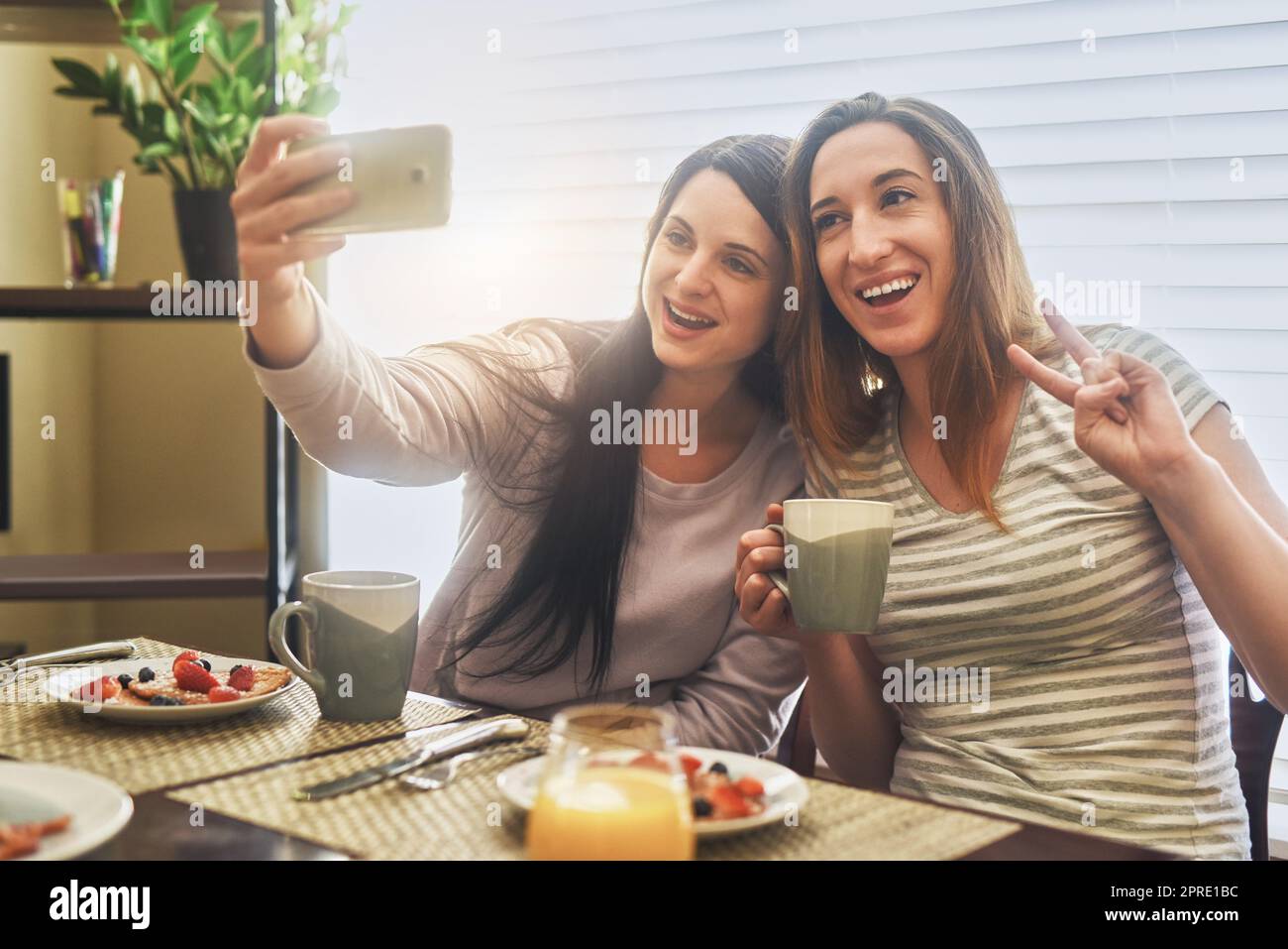 Weekends at home with my best friend. two young women having breakfast together in the morning at home. Stock Photo
