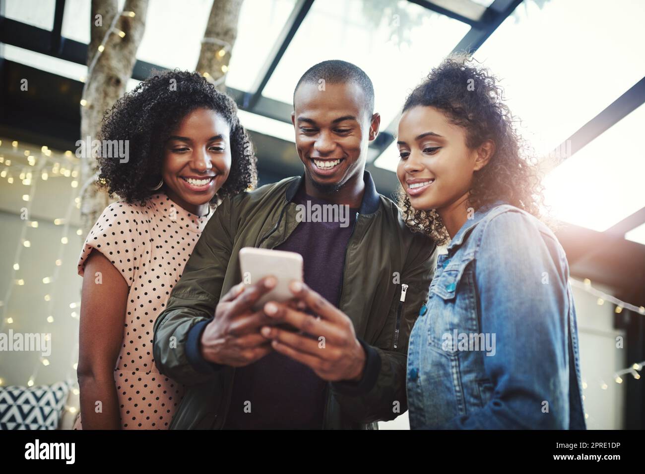 Im tagging you both in this post. three friends looking at something on a  cellphone Stock Photo - Alamy