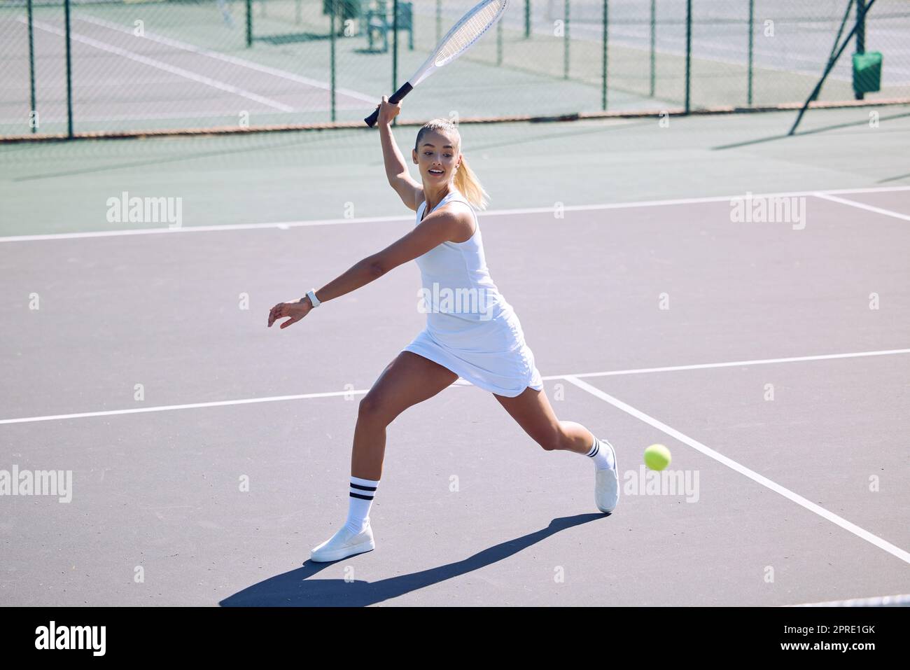 Fitness, balance and sport with athletic tennis player playing competitive match at a tennis court. Female athlete practicing her aim during a game. Lady enjoying active hobby shes passionate about Stock Photo