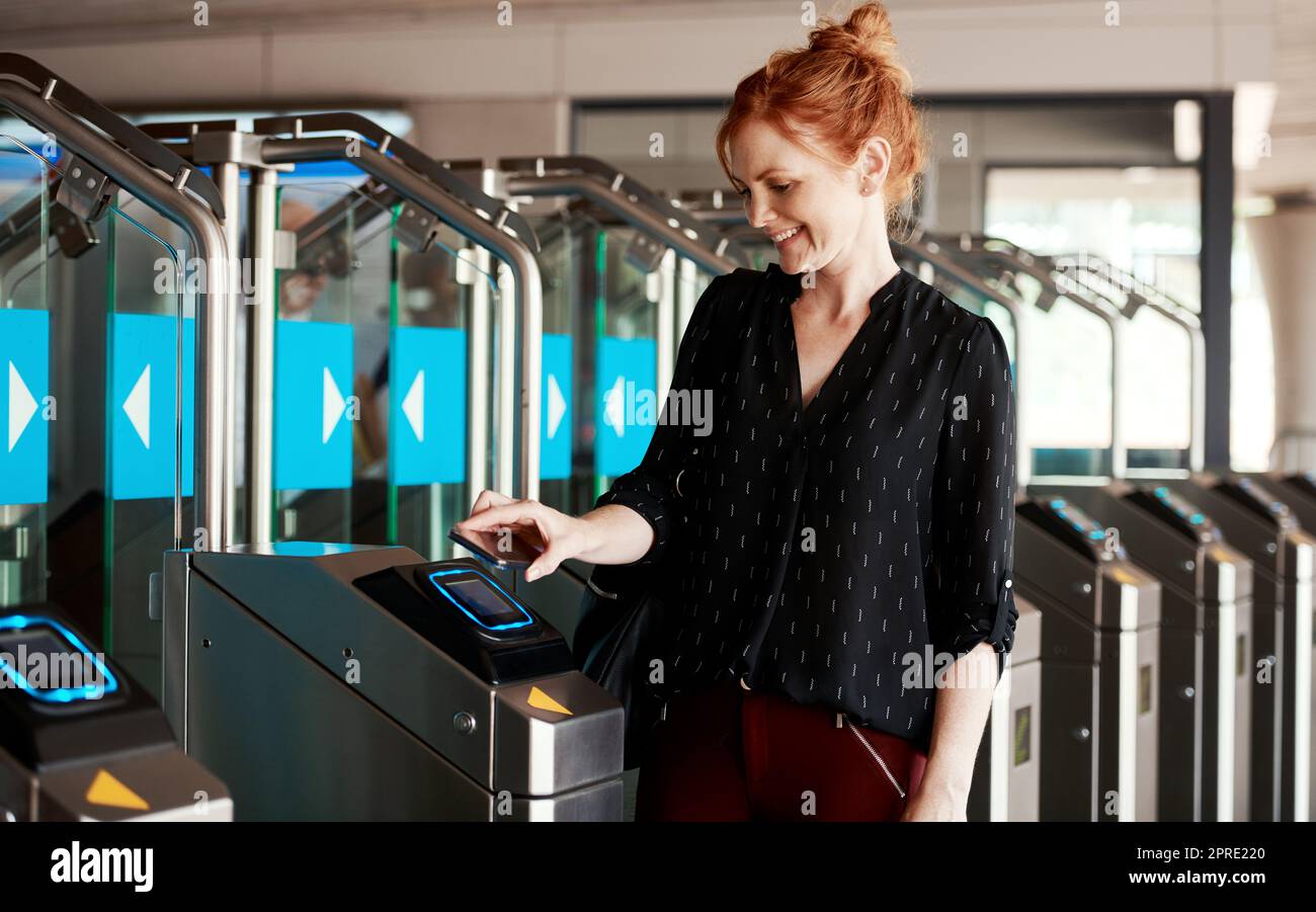 Woman scanning phone for entry into modern building or secure corporate company using contactless sensory scanner device or machine. Trendy lady using snap scan transaction to pay for parking ticket Stock Photo