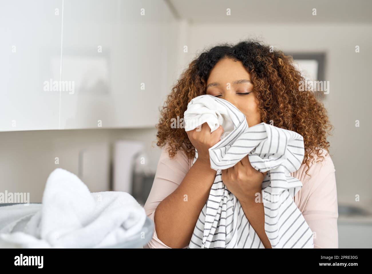 The refreshing smell of clean washing. a young attractive woman doing