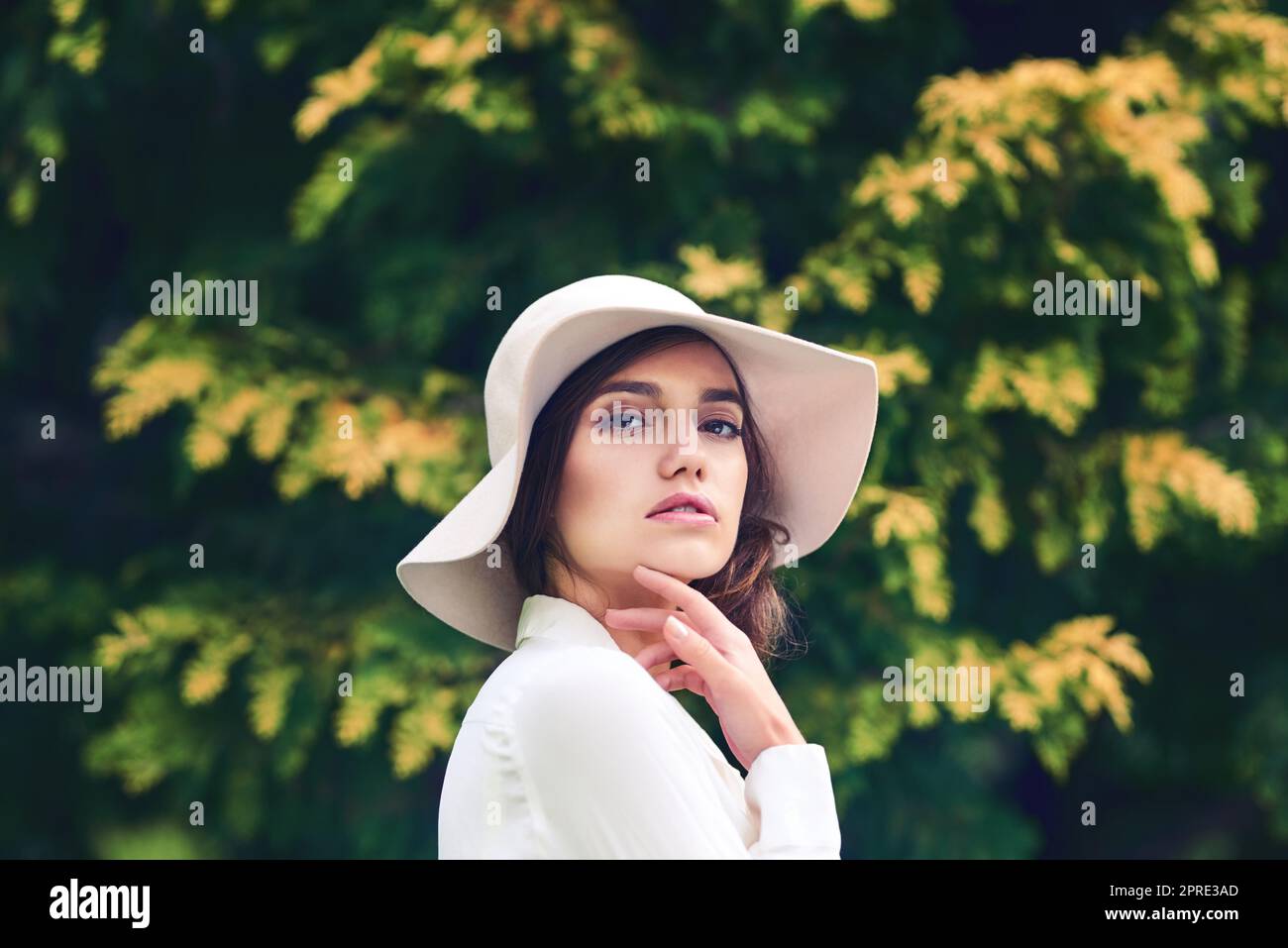 Beauty so enchanting. Portrait of an attractive young woman wearing a stylish hat outdoors. Stock Photo