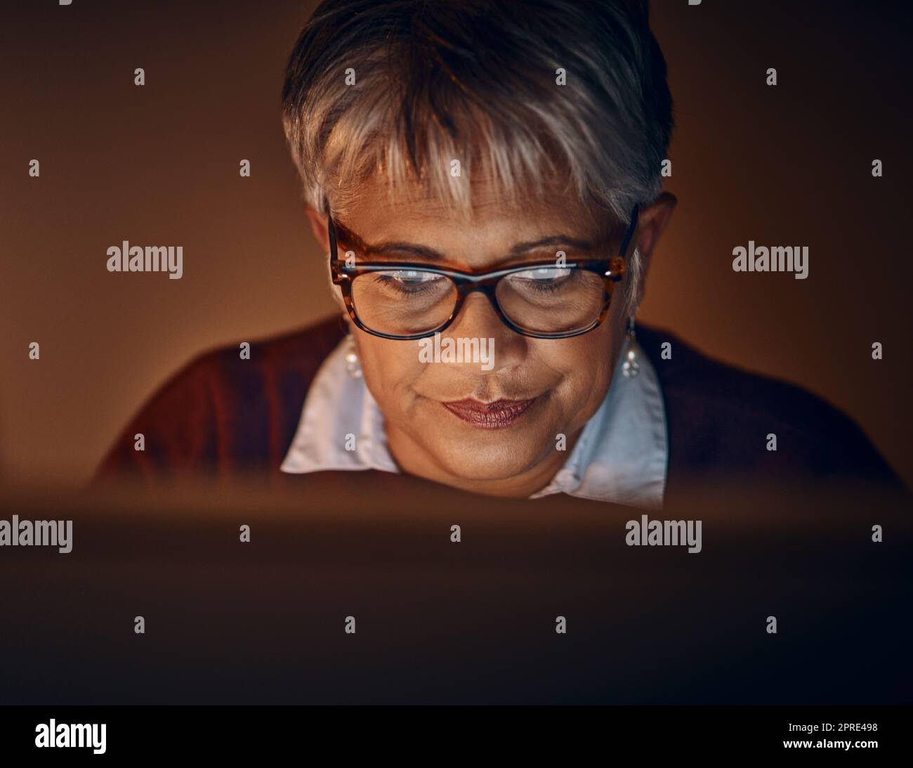 Shes got the determination to beat her deadlines. a mature businesswoman working late in an office. Stock Photo