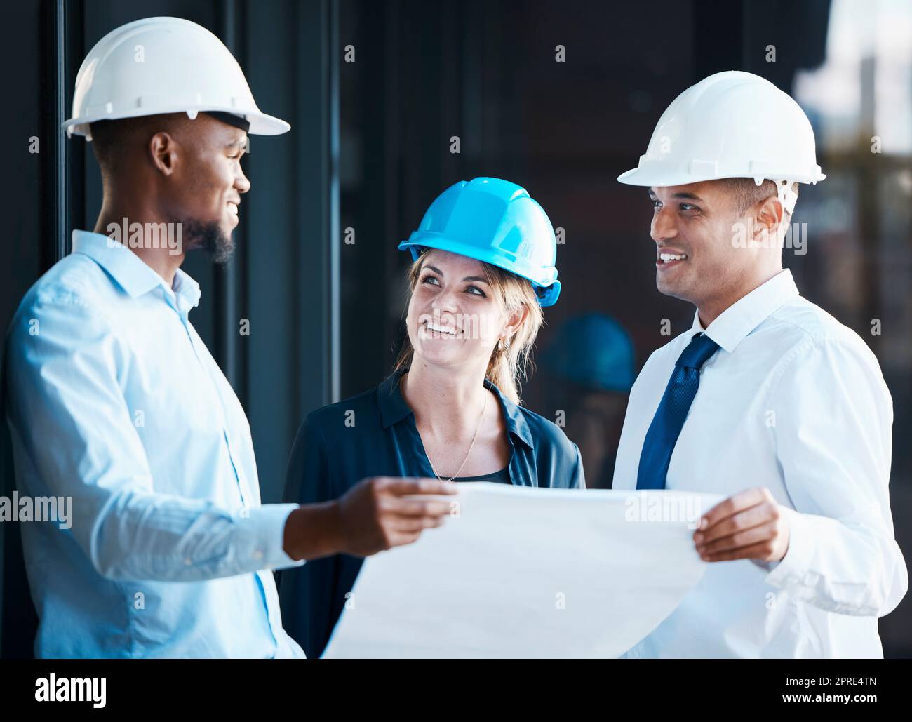 Architect, engineer and building contractor looking at plans or blueprints while talking and discussing strategy. Team or group of builders looking motivated and ready to develop, renovate or remodel Stock Photo