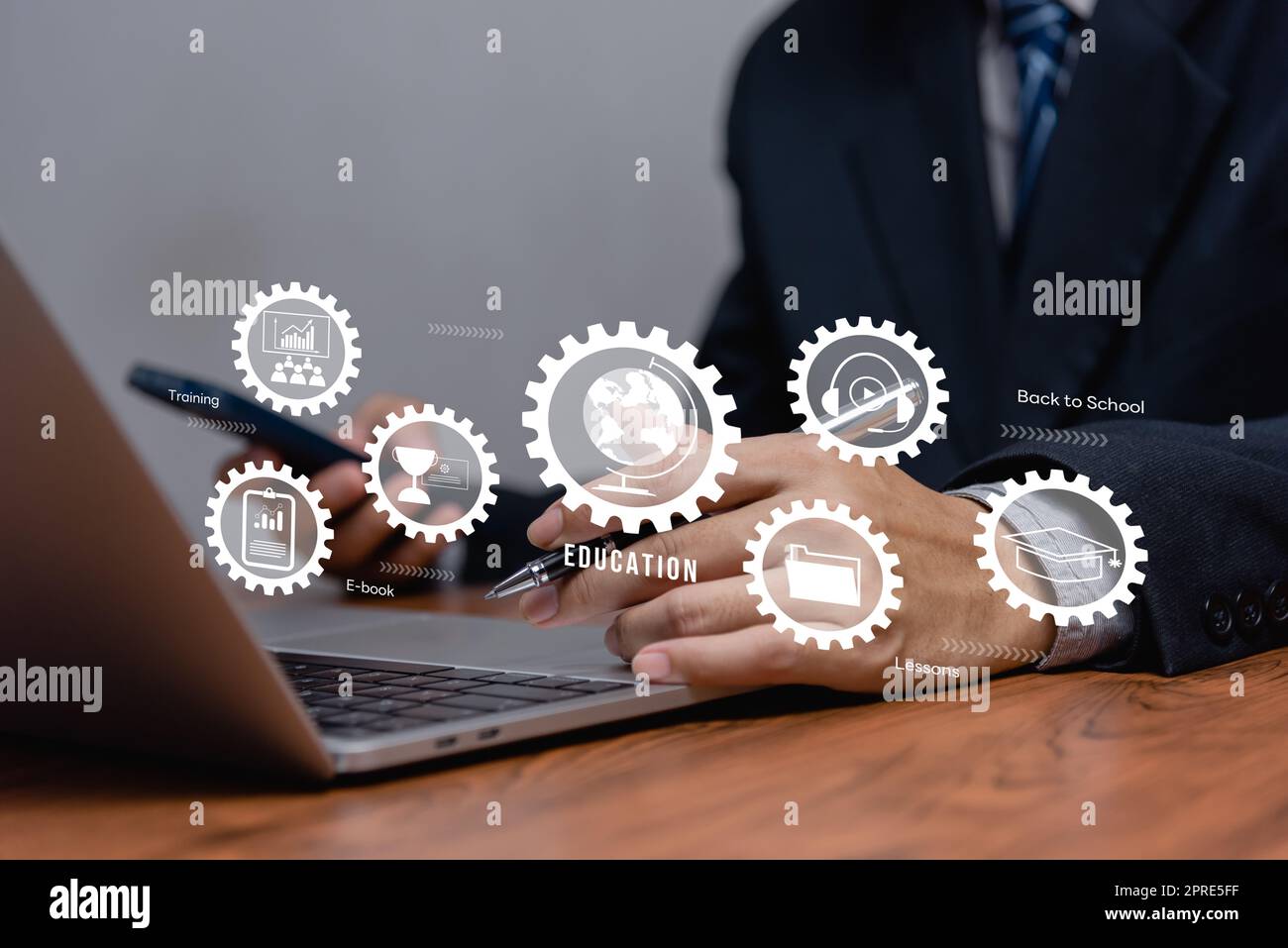 Businessman using laptop computer icon virtual screen education online and e learning on desk. Stock Photo