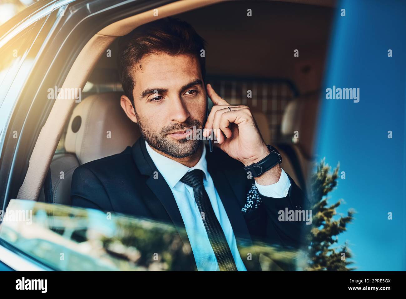 Calling the office to know whats happening. a handsome young corporate businessman on a call while commuting. Stock Photo