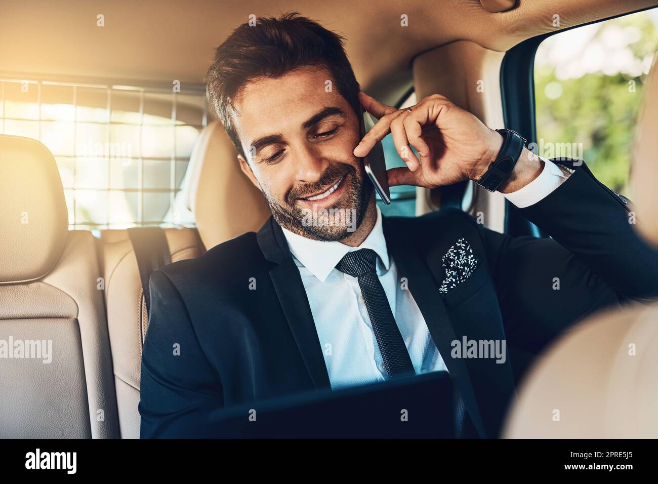 Hes hearing good news on hes way to the office. a handsome young corporate businessman on a call while commuting. Stock Photo