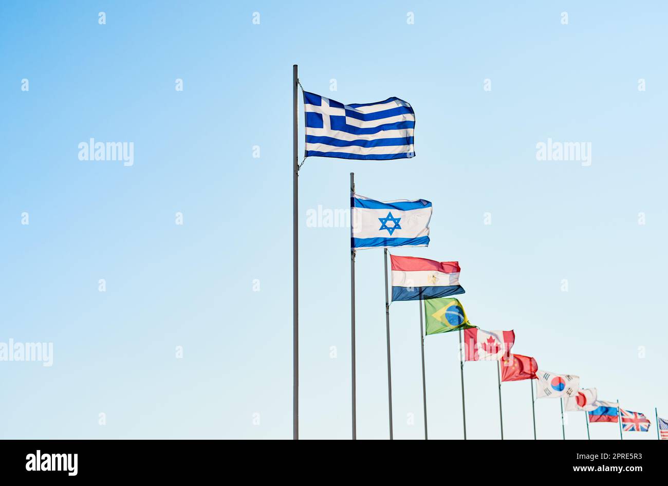 So much diversity. a variety of different kinds of countrys flags standing next to each other outside during the day. Stock Photo